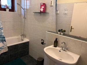 a bathroom with a sink and a toilet and a tub at Rigódal Vendégház in Eger +35 photos