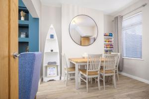 a dining room with a table and chairs and a mirror at Mournes Hot Tub Retreat, 4-Star Accommodation in Newcastle