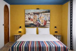 a bed in a room with a painting on the wall at Le balcon de tanger in Tangier +55 photos