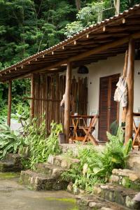 a porch of a house with a table and chairs at Fauna in Praia do Bananal