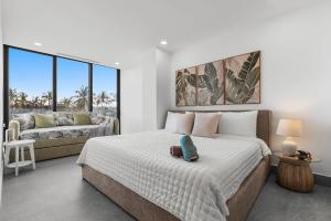 a white bedroom with a bed and a couch at UDARA - Beachfront Condos in Golden Zone with Rooftop in Bucerías