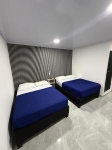 two beds in a room with blue sheets at Bless Hotel in San Andrés +12 photos