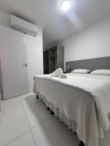 a white bedroom with a large bed and a closet at Dona Olivia Universidade 08 in Vitória da Conquista