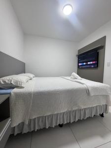 a bedroom with a white bed with a window at Dona Olivia Universidade 08 in Vitória da Conquista