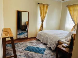 a bedroom with a bed and a large mirror at KFarm house in Kijabe