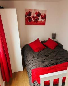 a bedroom with a bed with red pillows on it at Sun, Sand & Sheppey The Ultimate Escape in Leysdown-on-Sea