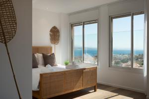 a bedroom with a bed and large windows at Kedem Eilat קדם אילת in Eilat