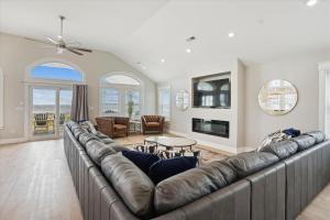 a large living room with a large leather couch at 5700 - La Cebolla in Nags Head