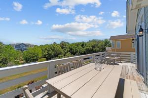 a wooden table on the balcony of a house at 4919 - The Leonardo in Kitty Hawk