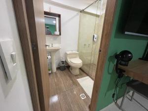 a bathroom with a toilet and a glass shower at Olivo House Casa Hotel in Envigado