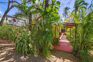 a house on the beach with a red boardwalk at Hotel Hibiscus in Playa Junquillal