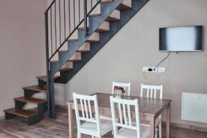 a dining room with a table and a staircase at Vigne dei Mastri in Costigliole dʼAsti