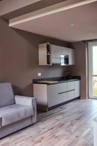 a living room with a couch and a kitchen at Vigne dei Mastri in Costigliole dʼAsti