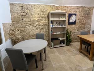 a table and chairs in a room with a stone wall at In Situ B&B in Uzès +14 photos
