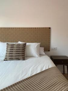 a white bed with two pillows on top of it at Salitre - Boa Onda in Cee