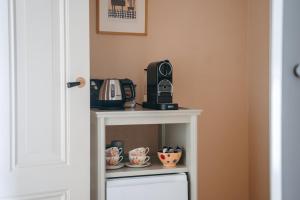 a coffee maker on top of a white table at B&B Chez Nous in Geesteren