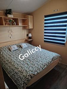 a bedroom with a bed with the word college on it at Caravan Galiccy in Kinmel Bay