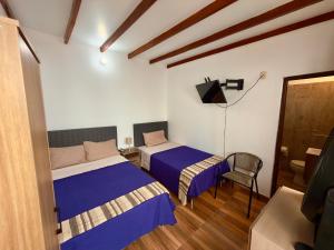 a bedroom with two beds and a chair in it at Huacachina Desert II in Ica +9 photos