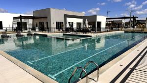 a swimming pool with blue water in front of a building at Dona Olivia Universidade 17 in Vitória da Conquista