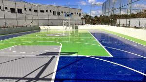 an empty court with a basketball hoop on a tennis court at Dona Olivia Universidade 17 in Vitória da Conquista