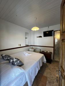 a bedroom with a bed and a tv on the wall at Pousada Nativa - Vista ao mar in Ilha de Boipeba +15 photos