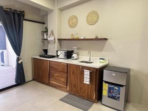 a kitchen with a counter with a sink and a refrigerator at Litos Hotel y Restaurante in Playa San Blas