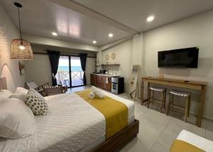 a bedroom with a bed and a kitchen and a television at Litos Hotel y Restaurante in Playa San Blas