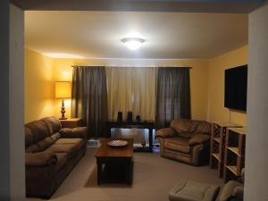 a living room with two couches and a television at Aurora House in Ironwood