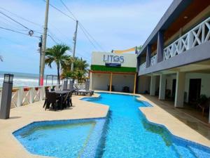 a hotel with a swimming pool next to the beach at Litos Hotel y Restaurante in Playa San Blas