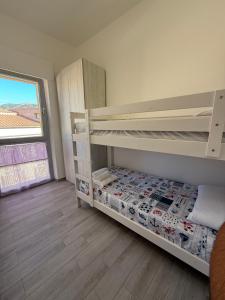 a bedroom with two bunk beds and a window at Alba&Tramonto in Arbus