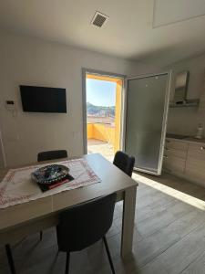 a dining room table with chairs and a view of a kitchen at Alba&Tramonto in Arbus