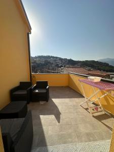 a balcony with chairs and a view of a city at Alba&Tramonto in Arbus