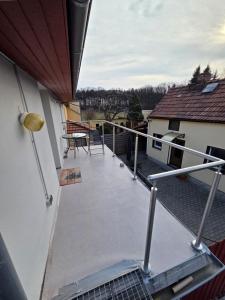 a balcony with a table and chairs on a house at Moderne Dachgeschosswohnung am Wald in Großnaundorf +2 photos