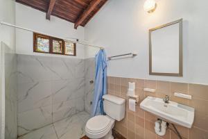 a bathroom with a toilet and a sink and a shower at Hotel Hibiscus Cabina 4 in Playa Junquillal