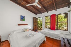 a bedroom with two beds and a ceiling fan at Hotel Hibiscus Cabina 4 in Playa Junquillal