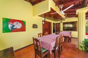 a dining room with a table and chairs and a painting at Hotel Hibiscus Cabina 4 in Playa Junquillal +16 photos