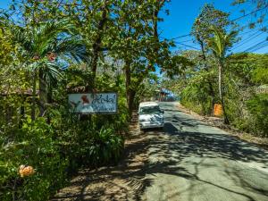 a car parked on the side of a road with a sign at Hotel Hibiscus Cabina 4 in Playa Junquillal