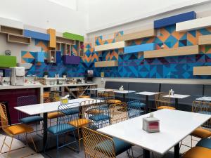 a dining room with tables and chairs and a colorful wall at Ibis Styles Mexico Reforma in Mexico City
