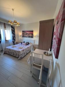 a bedroom with a bed and a table in it at Monolocale Pink Borgo Roma GB Rossi friendly Verona in Verona