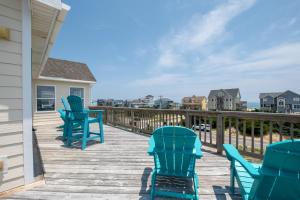 a deck with blue chairs and a table at 7676 - Nautical by Nature in Avon