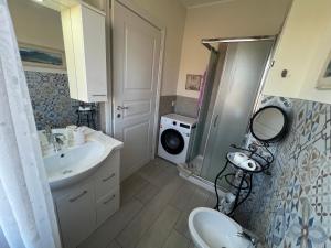 a bathroom with a sink and a washing machine at Monolocale Pink Borgo Roma GB Rossi friendly Verona in Verona