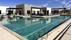 a swimming pool with blue water in front of a building at Dona Olivia Universidade 16 in Vitória da Conquista