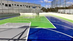 an empty court with a basketball hoop on a tennis court at Dona Olivia Universidade 16 in Vitória da Conquista