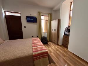 a bedroom with a bed and a television on the wall at Huacachina Desert II in Ica