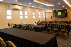 a conference room with tables and chairs and a screen at Ibis Styles Mexico Reforma in Mexico City