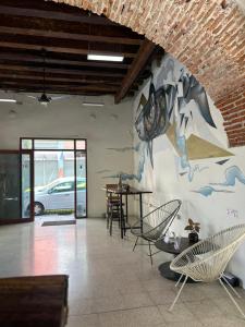 a room with chairs and a mural on the wall at Hotel Cataviento in Veracruz