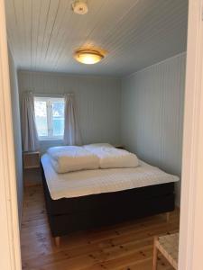 a bedroom with a bed in a room with a window at Nusfjord Ocean View Rorbu 19 in Ramberg