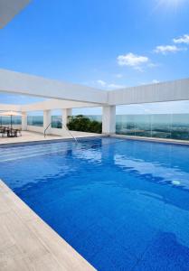 a swimming pool on the roof of a building at Zen Living Sky Suite in SamborondÃ³n