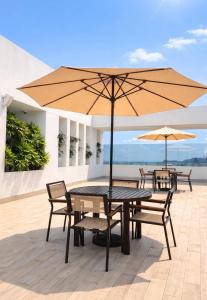 a table and chairs with an umbrella on a patio at Zen Living Sky Suite in SamborondÃ³n