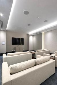 a waiting room with couches and a flat screen tv at Zen Living Sky Suite in SamborondÃ³n